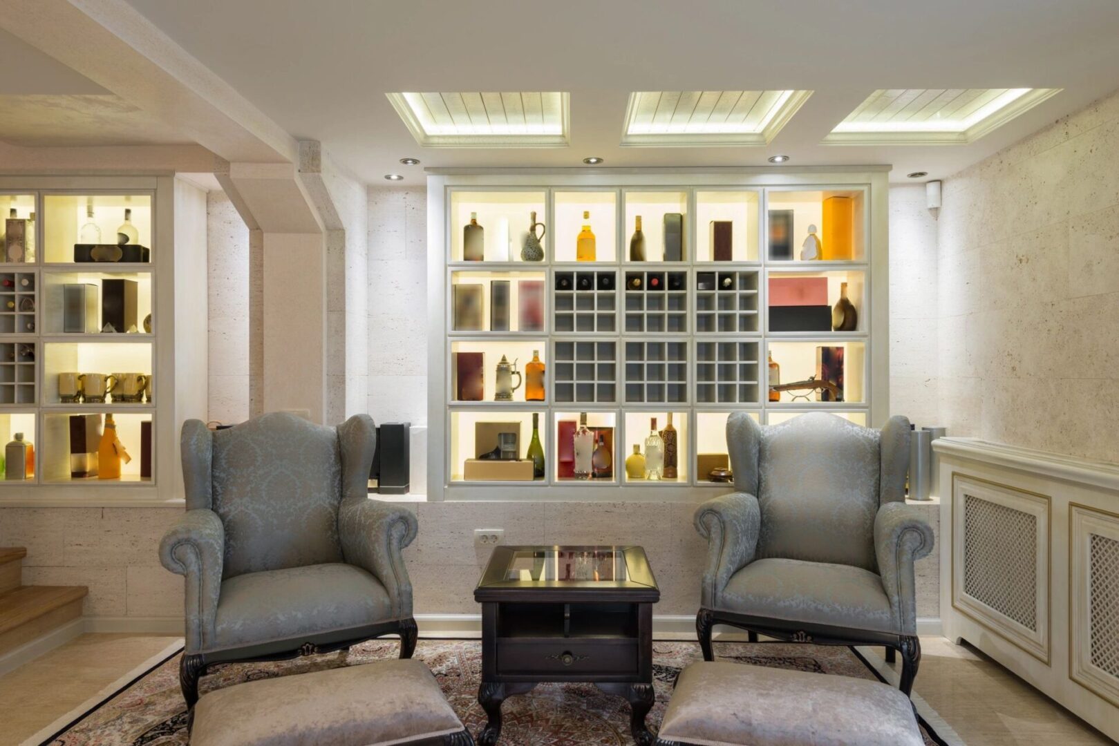 A room with elegant chairs and a wine shelf.